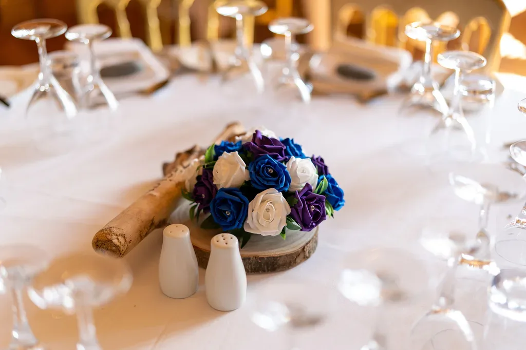 a bouquet of flowers on a table with wine glasses.