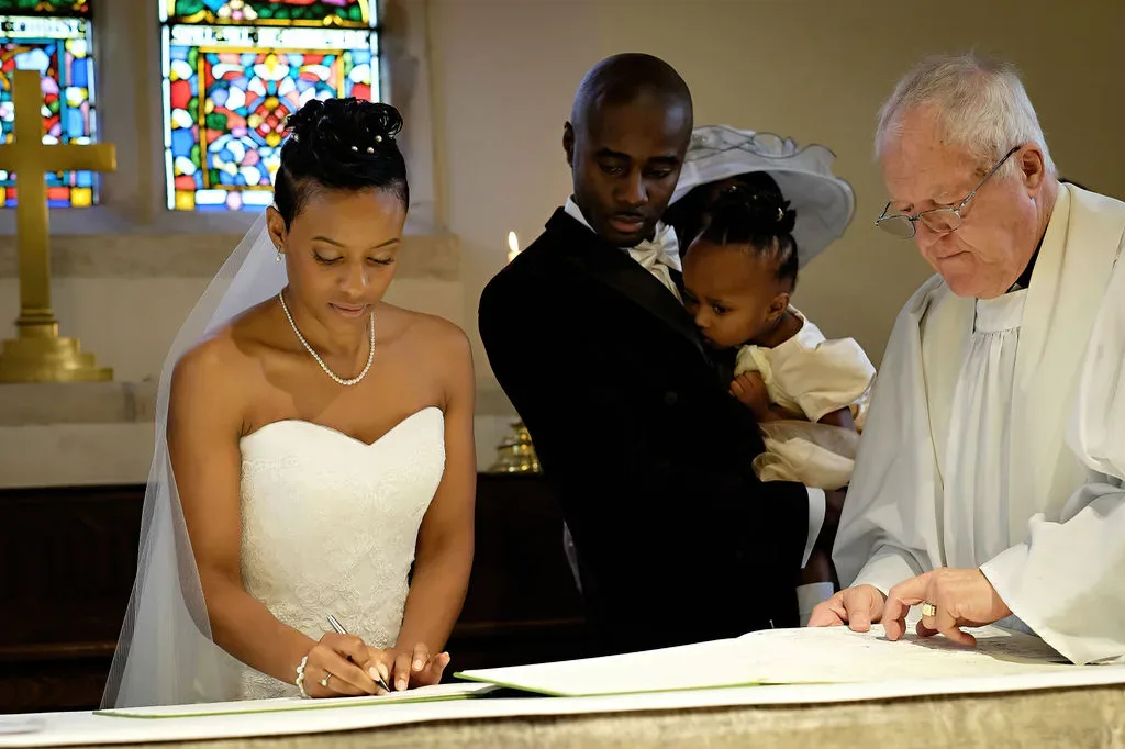 a bride and groom are signing the register of their wedding.