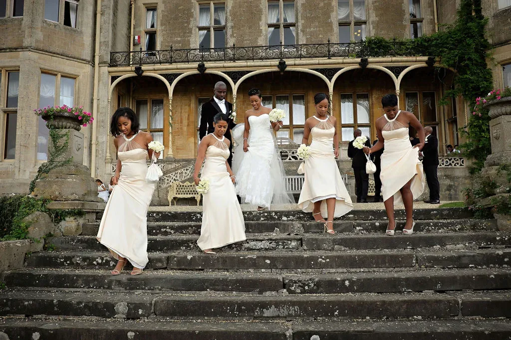 Orchardleigh House Wedding Photographer: a group of women in white dresses standing on steps.