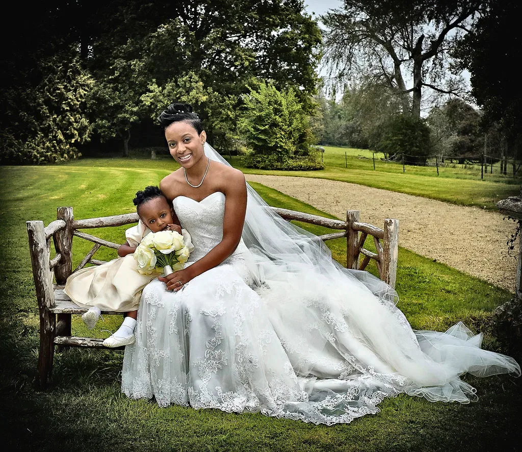 a bride and her daughter sitting on a bench at Orchardleigh House Frome