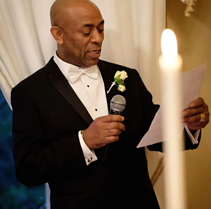 Speech by the Father of the Bride at Orchardleigh House: a man in a tuxedo holding a microphone.
