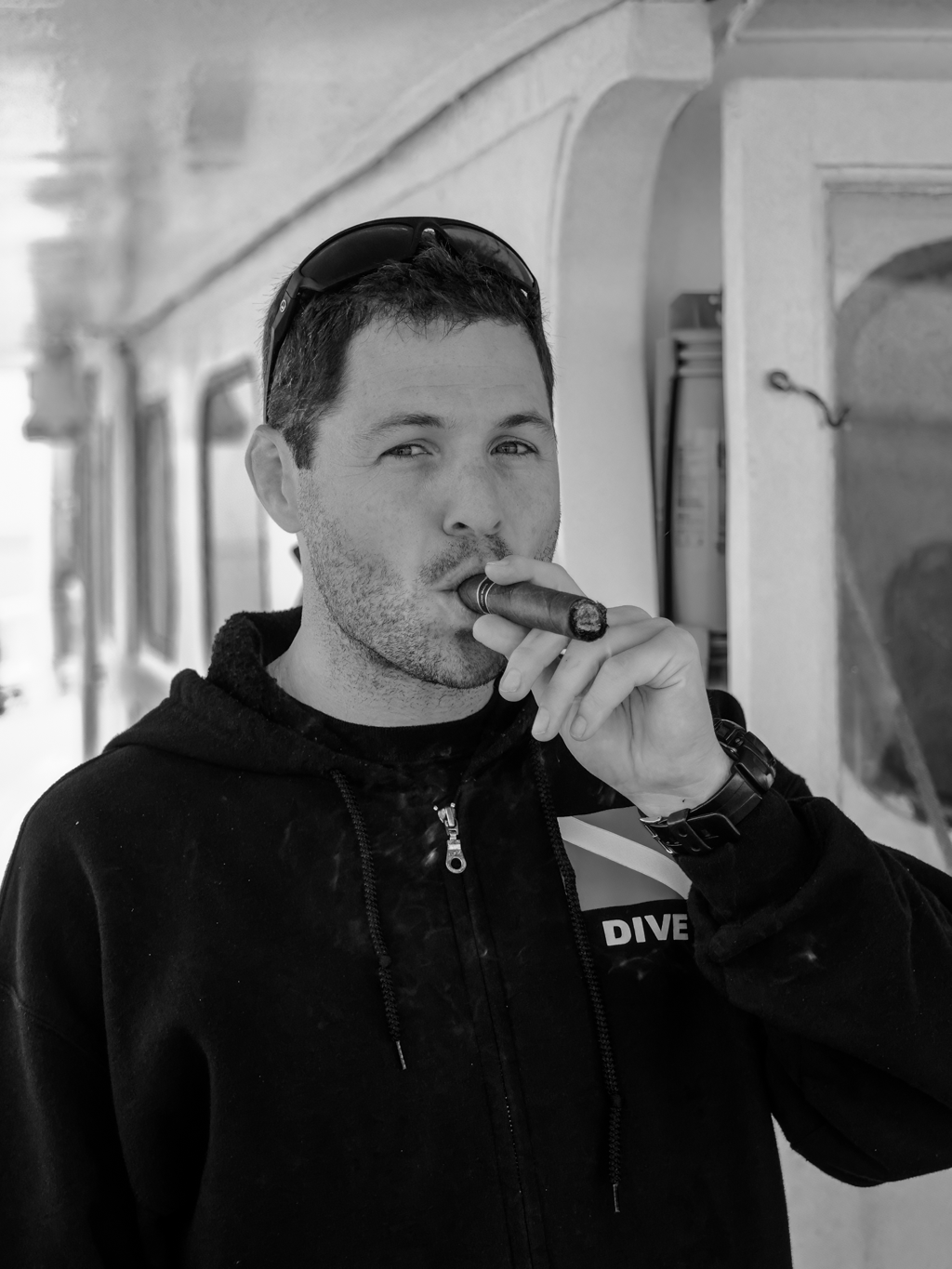 a man smoking a cigarette in a black and white photo.