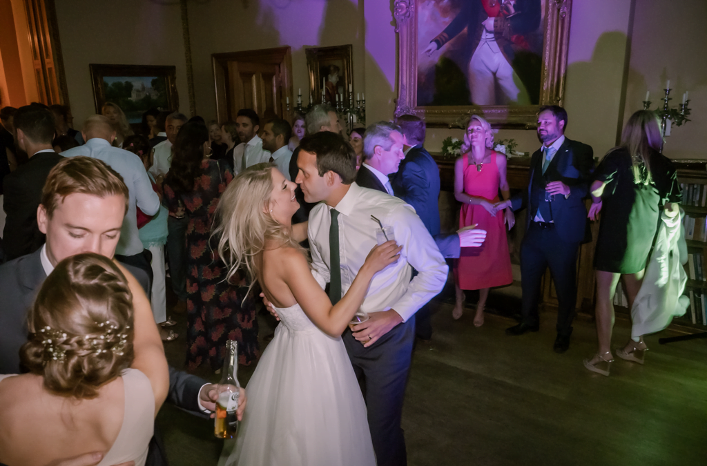 a bride and groom kissing on the dance floor.