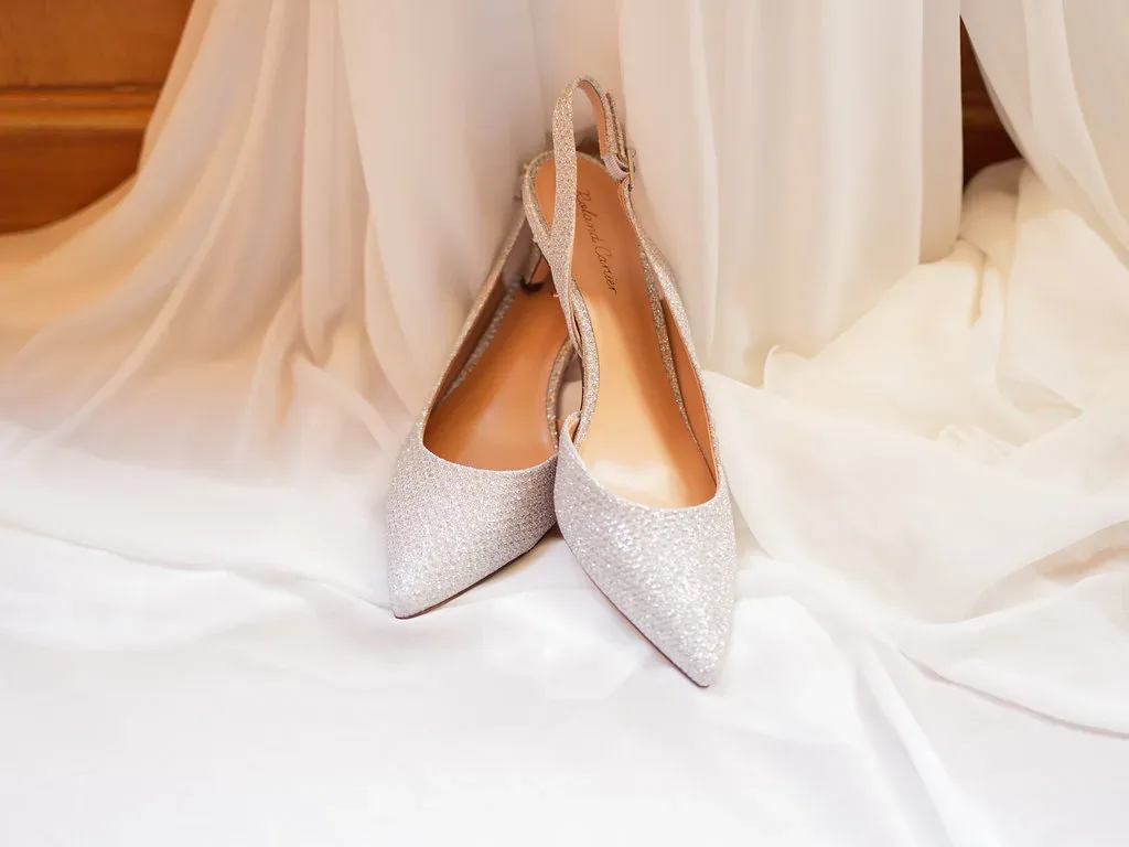 Orchardleigh Wow: a pair of silver shoes sitting on top of a bed.