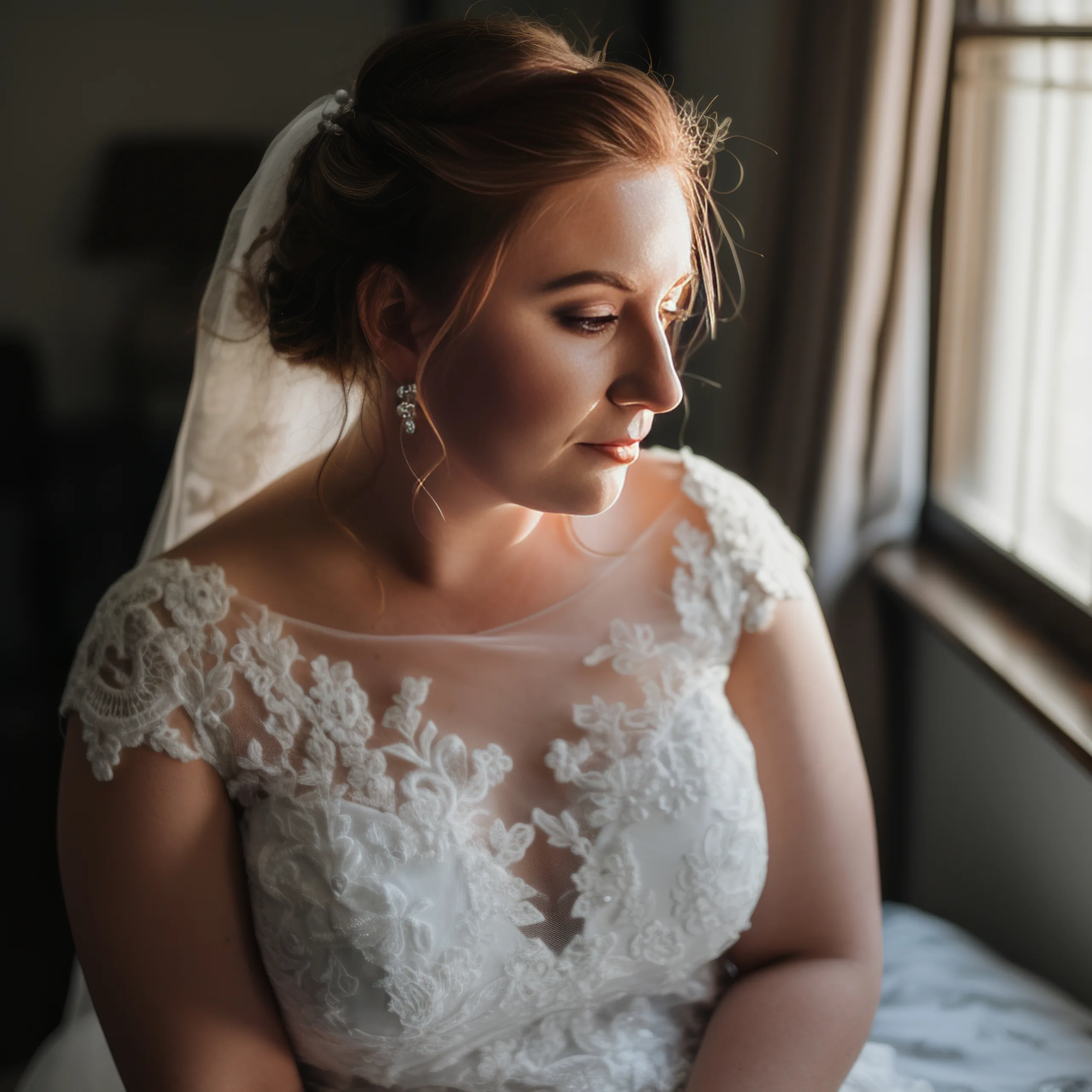 The more curvy Bride:a woman in a wedding dress looking out a window.