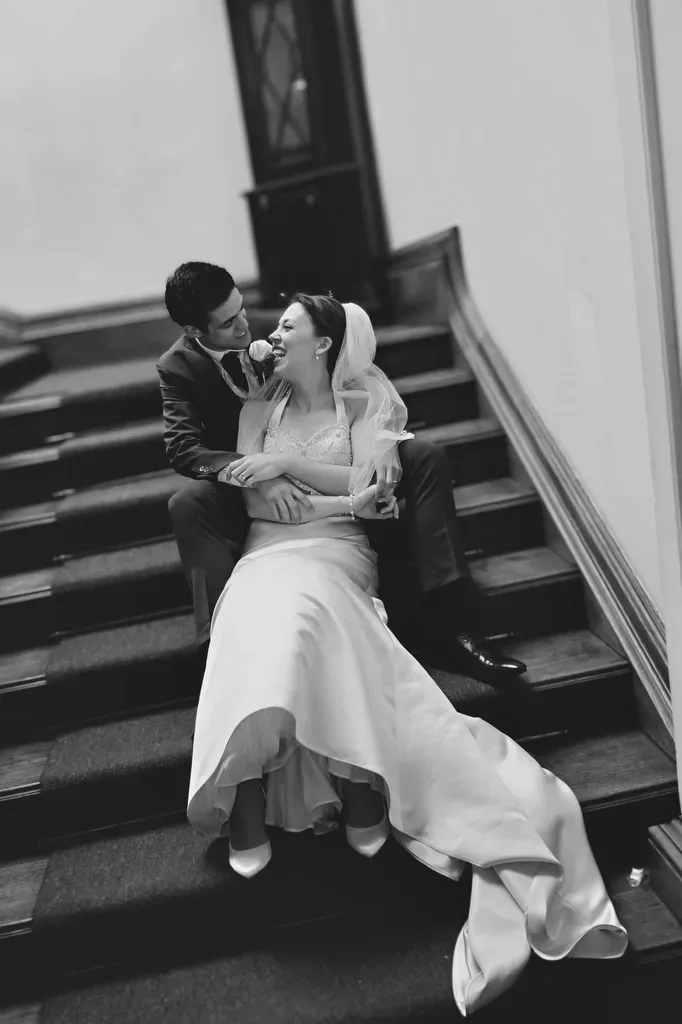 The Amazing Orchardleigh House: a bride and groom sitting on the stairs of a building.
