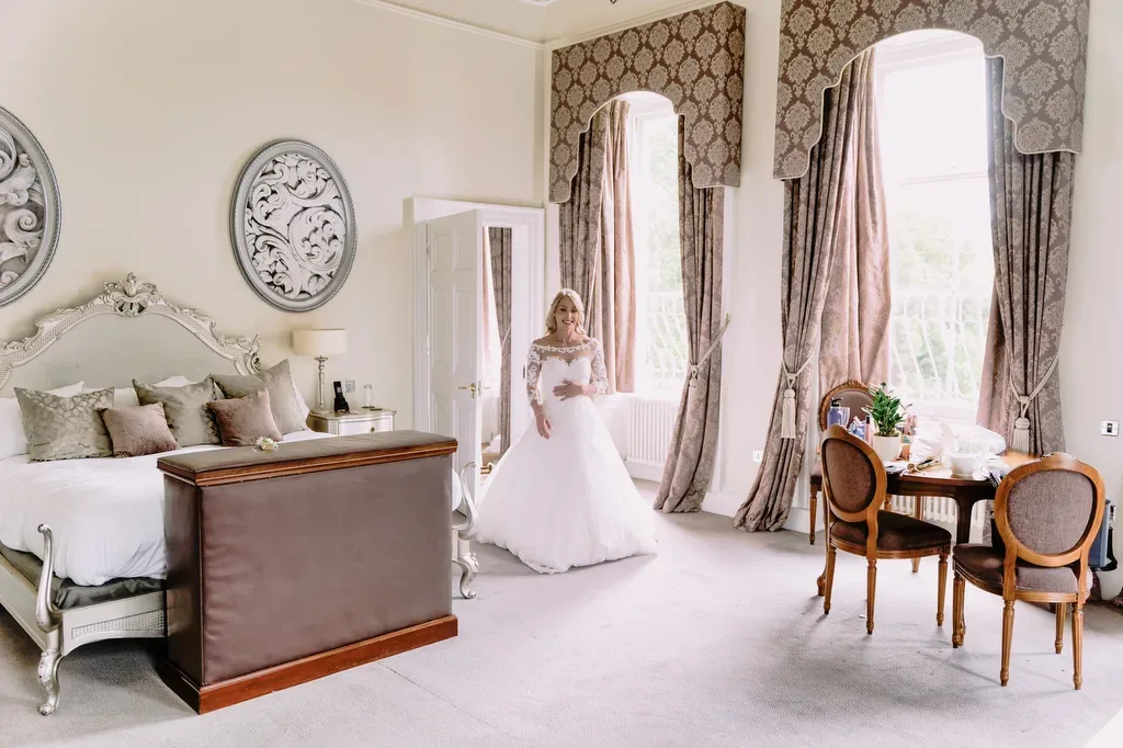Bailbrook Weddings: a woman in a wedding dress standing in a bedroom.