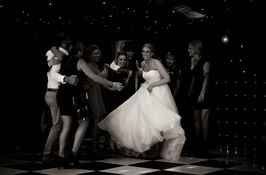 Makin it fun at your wedding:a bride and groom dance on a checkered floor.