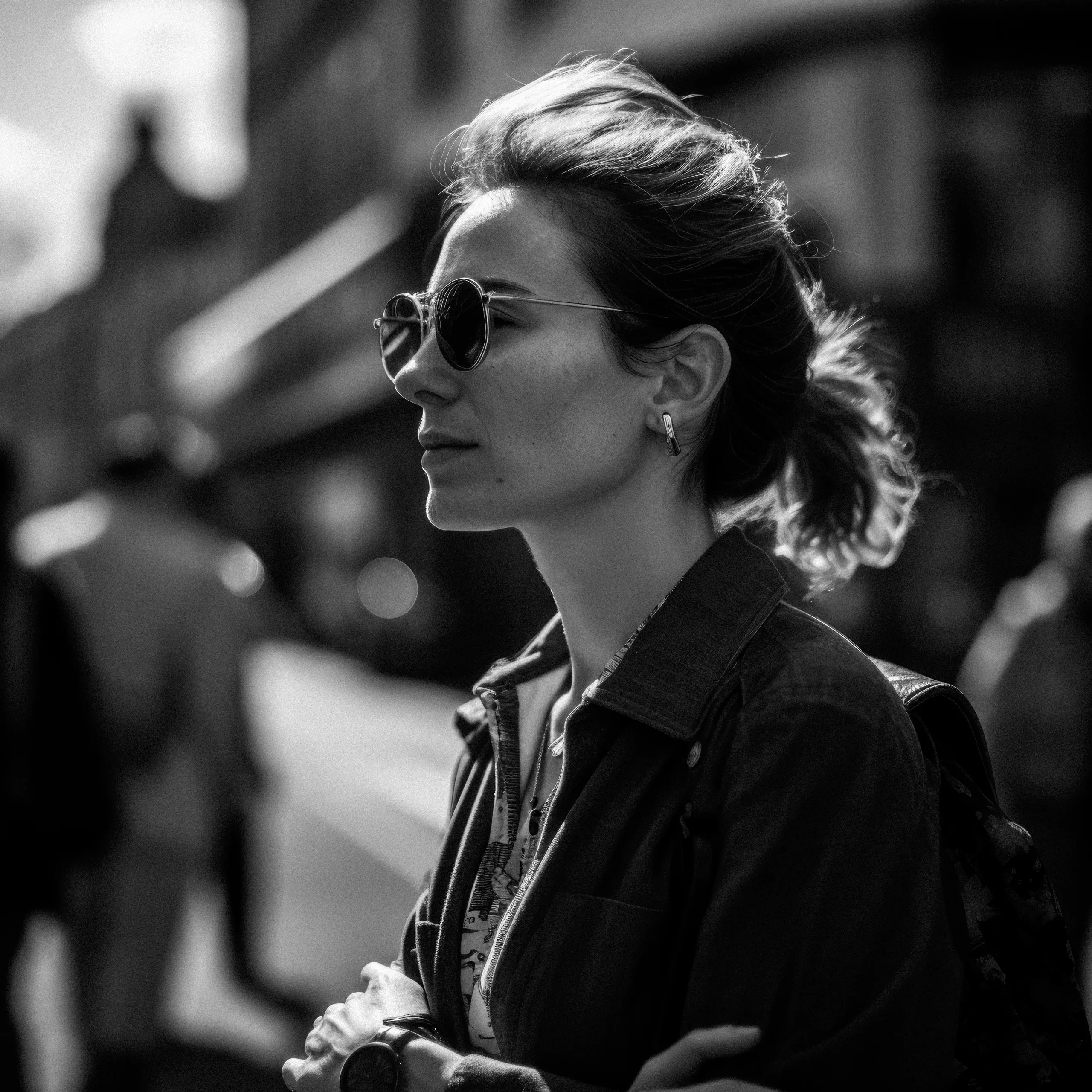 Street Photography:a woman in sunglasses is standing on the street.