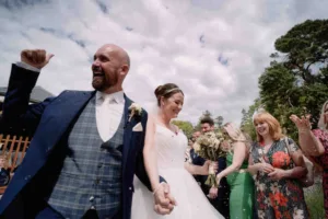a bride and groom walking through a group of people.Who to invite