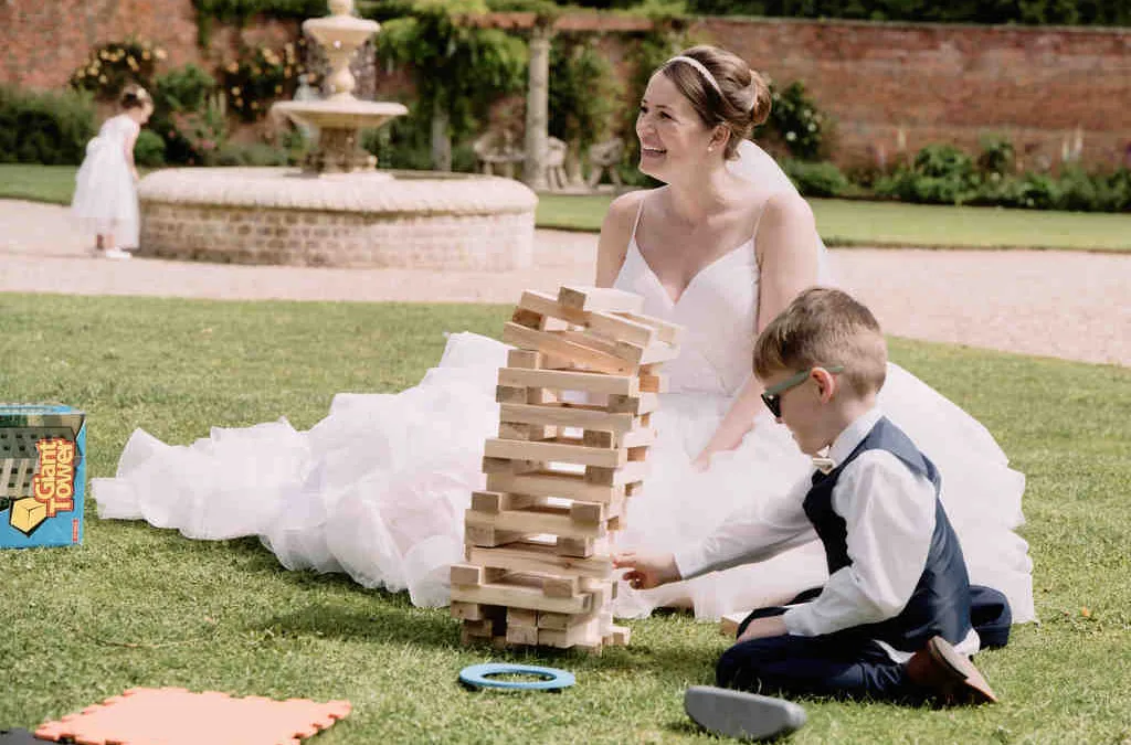 Entertainment: a bride and groom playing with a tower of blocks.