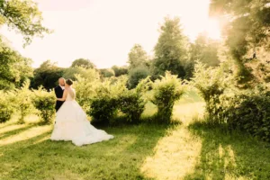 a bride and groom standing in a field at Wick Farm