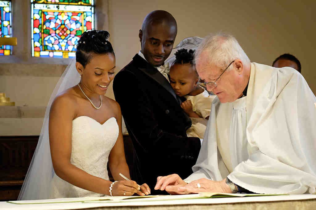 a bride and groom signing the register of their wedding.
