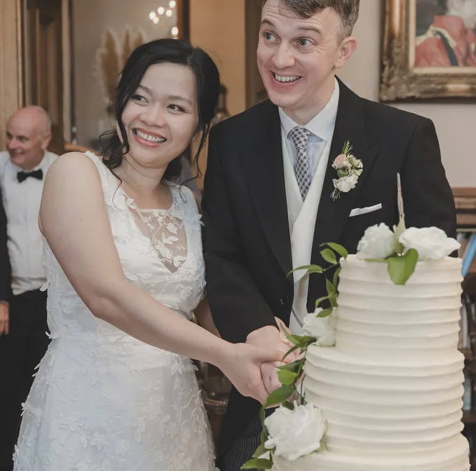 a bride and groom cutting their wedding cake. Wedding Photography UK
