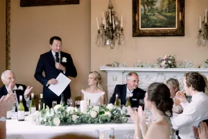 Castle Combe Manor Wedding Photographer captures a man giving a speech at a wedding reception.