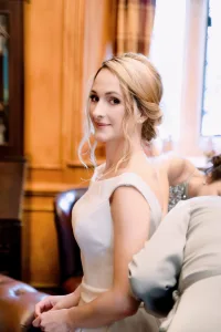 A bride is getting ready in the enchanting Castle Combe Manor for her wedding, captured beautifully by the skilled Wedding Photographer.