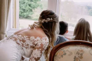 A bride looking out of a window with her children captured by Orchardleigh House Wedding Photographer.