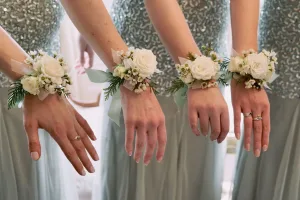 A group of bridesmaids wearing flowers on their wrists at an Orchardleigh House wedding.