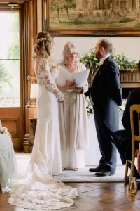 Orchardleigh House Wedding Photographer captures a stunning bride and groom as they exchange vows in an ornate room.