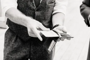 Orchardleigh House Wedding Photographer captures a stunning black and white photo of a man holding a wallet.