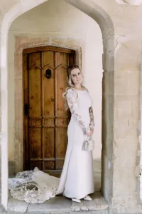 A bride in a white wedding dress standing in an archway at Orchardleigh House.