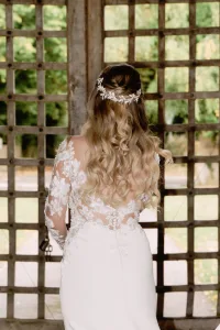 A beautiful bride in a wedding dress looking out of a window at Orchardleigh House.