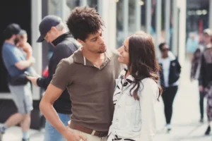 A couple sharing a tender moment on a busy street during their complimentary engagement photo shoot.