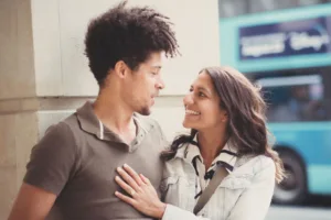 A smiling couple looking at each other affectionately during their complimentary engagement photo shoot.