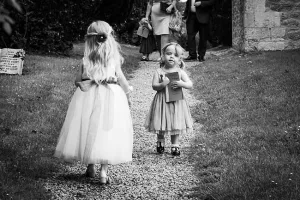 A black and white photo of two little girls walking down a path, captured by a Wedding Photographer at Orchardleigh.
