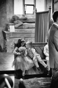 A black and white photo capturing a passionate kiss between a bride and groom, expertly captured by Orchardleigh's top wedding photographer.