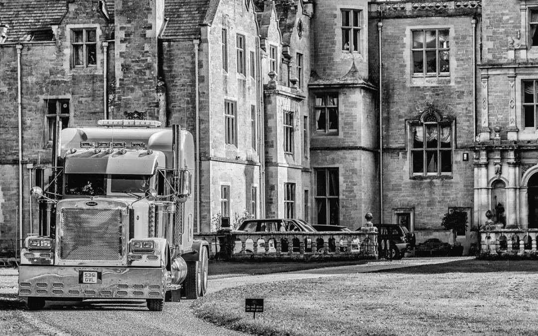 A black and white photo of a semi truck in front of a castle, captured by an Orchardleigh House Wedding Photographer.