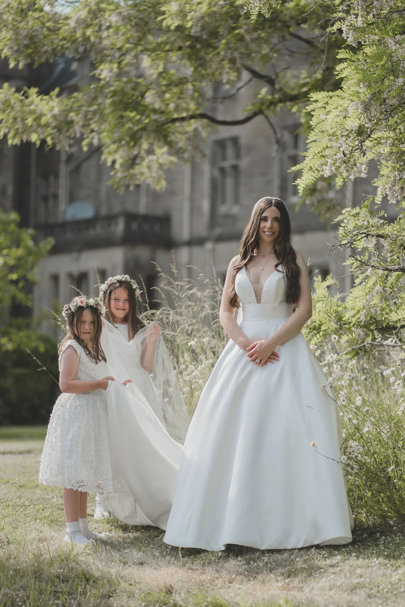 Three girls in wedding dresses standing in front of Orchardleigh House