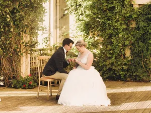 Orchardleigh House Wedding Photographer captures a beautiful moment as a bride and groom sit on a wooden deck.