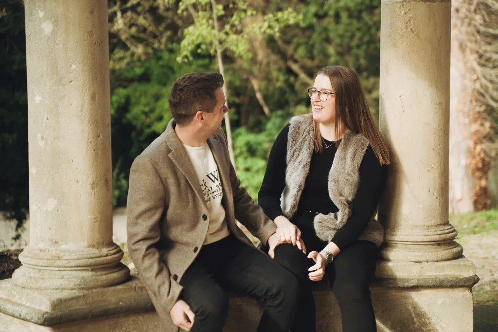 A couple sitting on a bench in a park. Photo shoot in bath