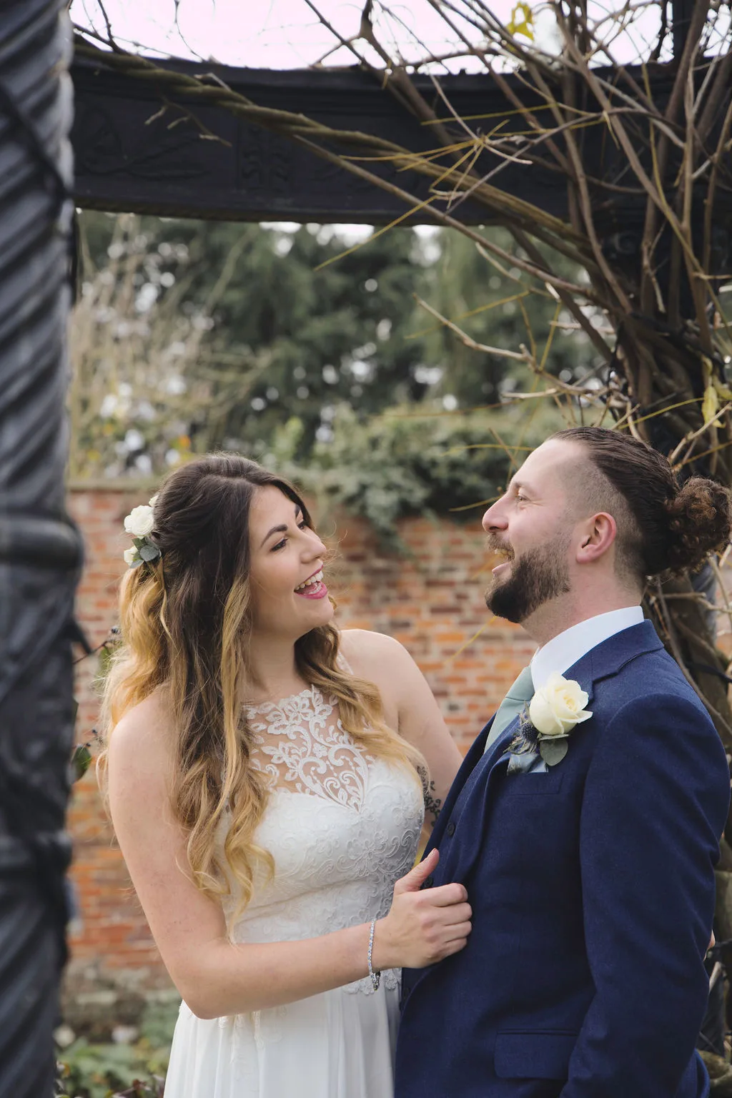 Elmhay Park Wedding Photographer captures a joyous bride and groom smiling in front of an arbor.