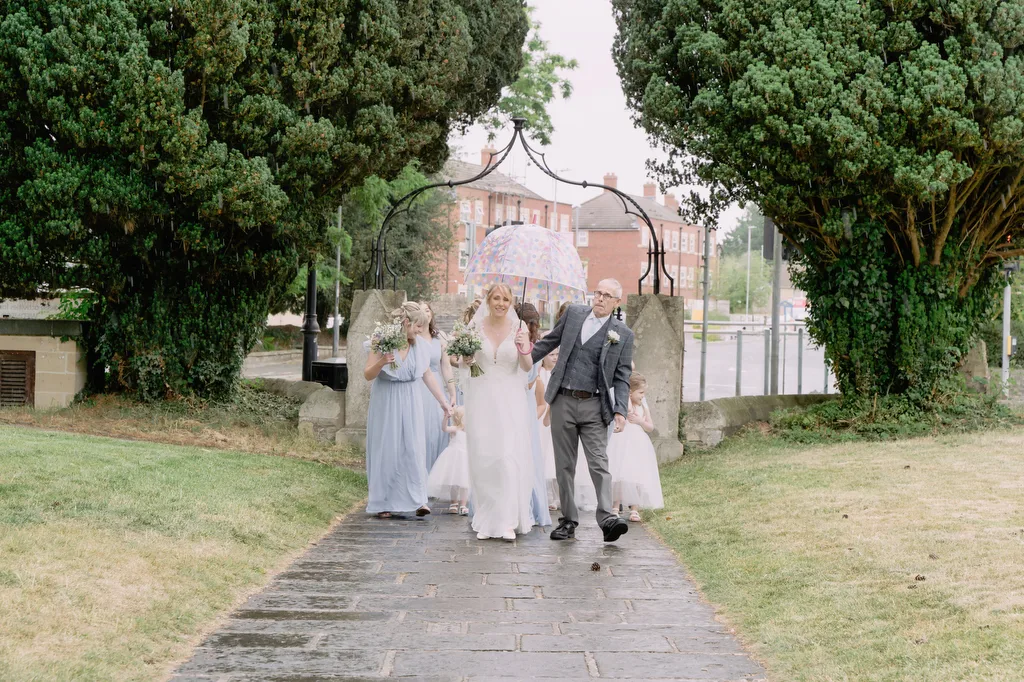 Bride walking toward St James Church by Trowbridge Wedding Photographer