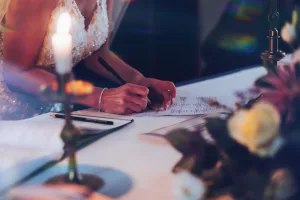 A bride signing her wedding vows at a table with candles. Captured in beautiful Orchardleigh House photos.