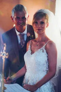 A couple joyfully signing their wedding vows at Orchardleigh House, captured in beautiful photos.