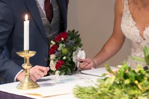A Wedding Photographer capturing the moment of a bride and groom signing a wedding certificate at Orchardleigh.