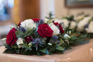 A stunning bouquet of red, white and blue flowers on a table, captured beautifully by the wedding photographer at Orchardleigh.