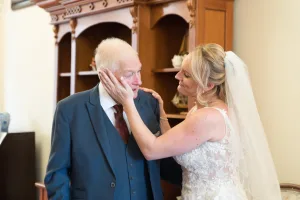 A wedding photographer captures the heartfelt moment when a bride kisses her father on the cheek at Orchardleigh.