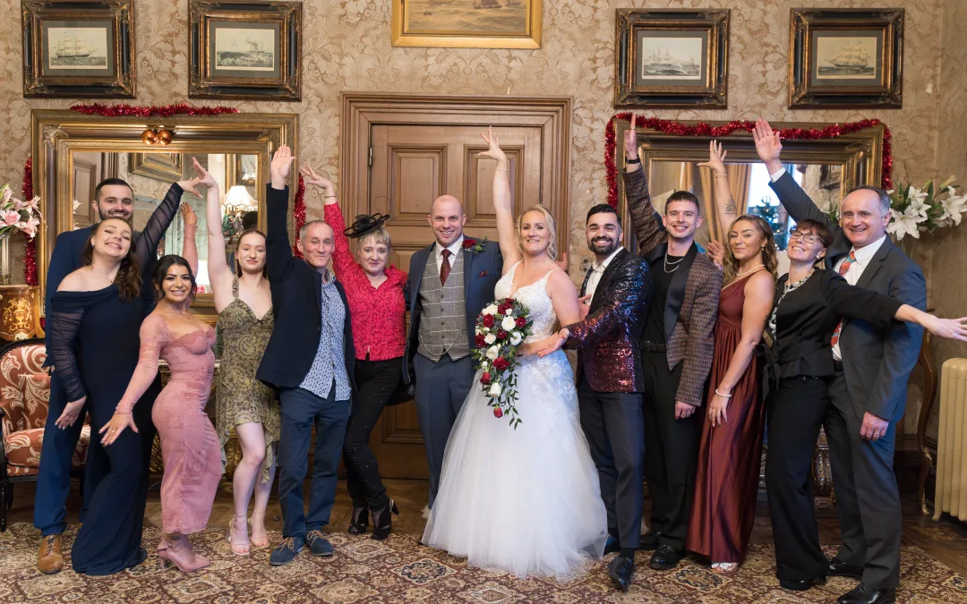 Orchardleigh's wedding photographer captures a picture-perfect moment as the wedding party poses in an ornate room.
