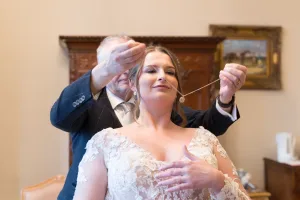 A bride getting her hair done for her wedding by a man in a suit at Orchardleigh.