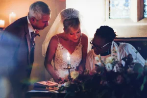 A bride and groom lighting a candle in Orchardleigh House Photos.
