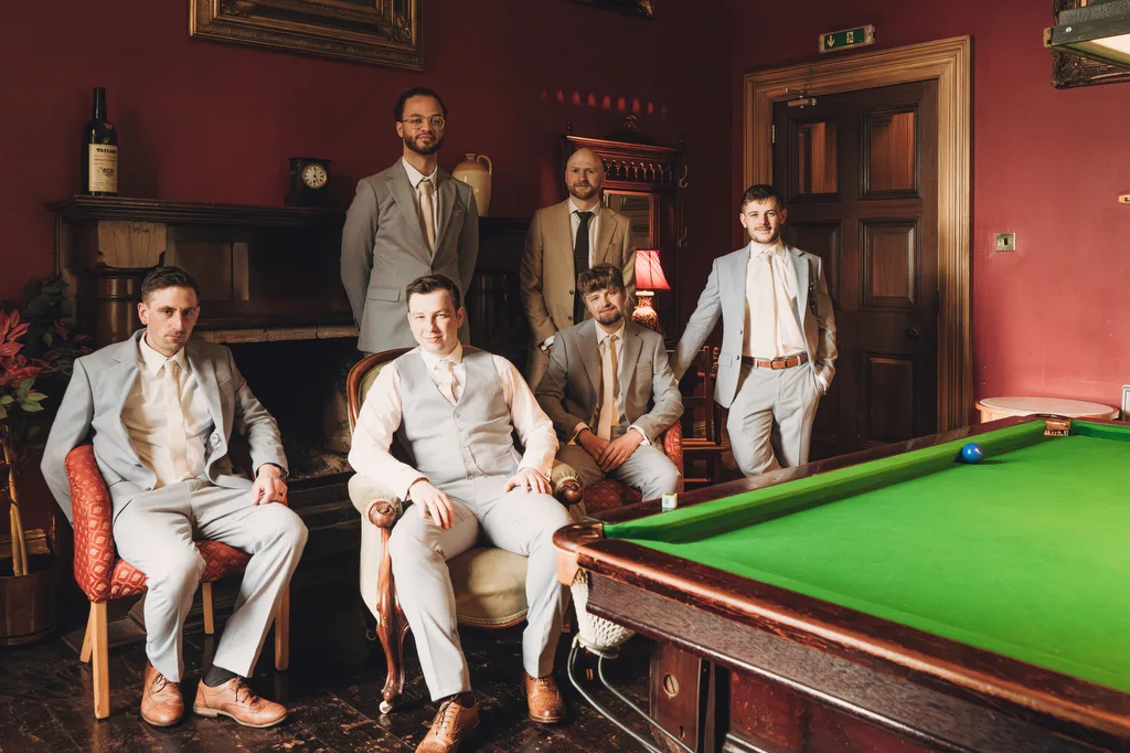 Orchardleigh49 Group of six men in formal attire posed around a billiards table in an elegant room at Orchardleigh House Weddings.