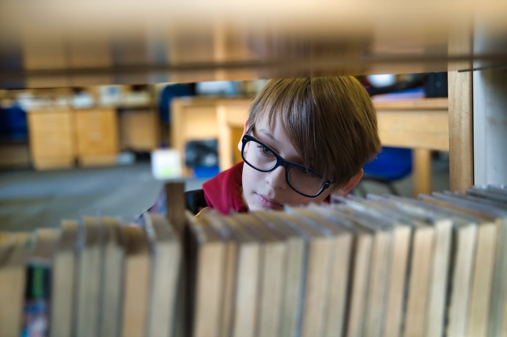 Marketing Photography of a lad looking through books