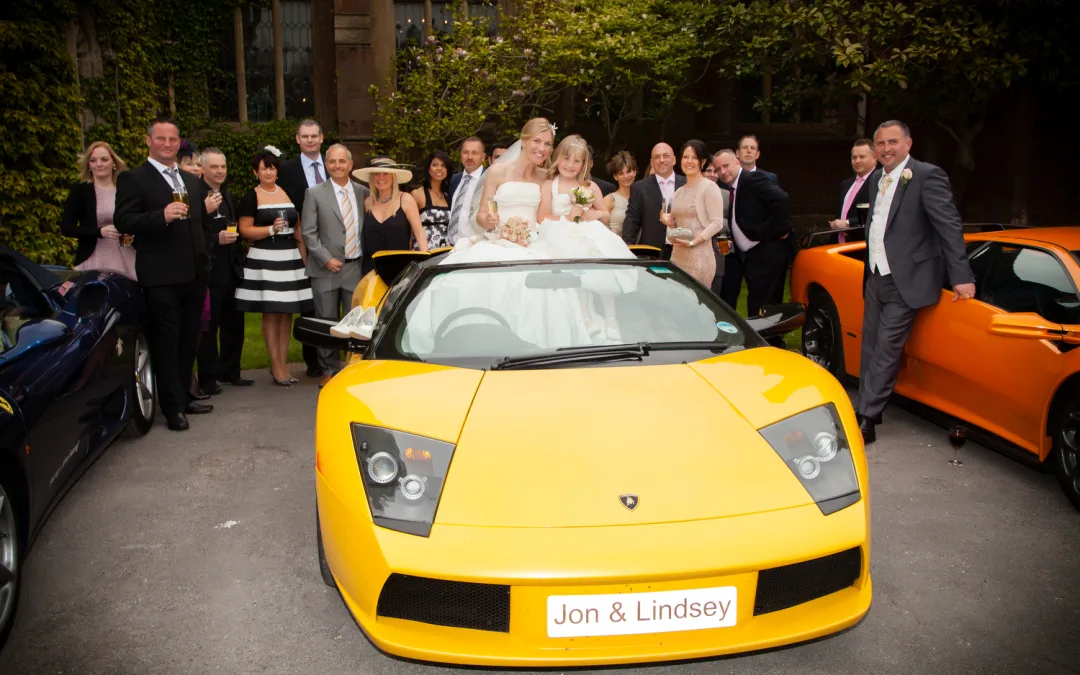 A wedding party posing with a yellow sports car at St Andrie's park.