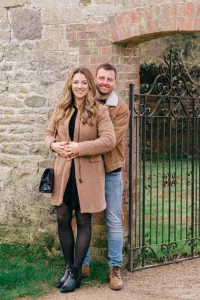 Stourhead Wedding Photographer: A couple posing in front of an old stone gate.