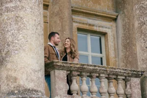 Stourhead Wedding Photographer29 Stourhead Wedding Photographer captures a couple standing on the balcony of a building.