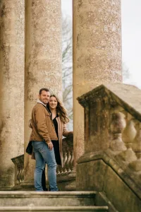 Stourhead Wedding Photographer31 A Stourhead wedding photographer capturing an engaged couple standing on the steps of a building.